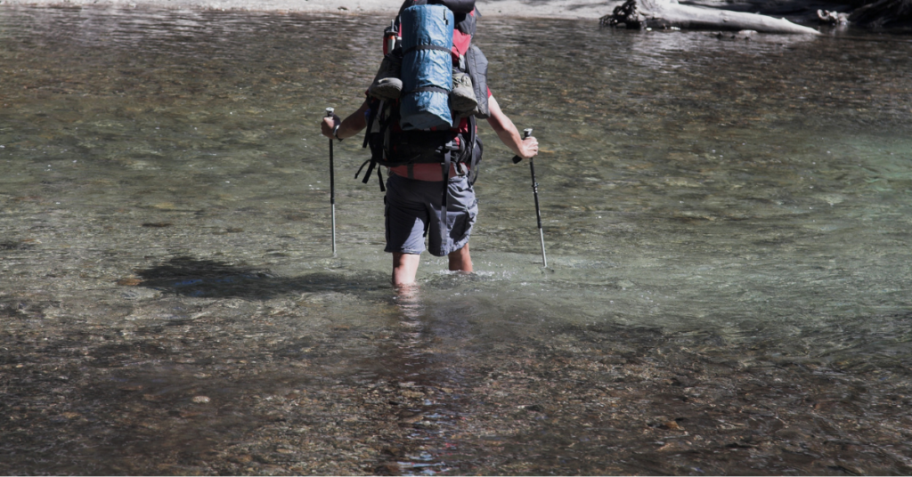 Hiker Crossing The River